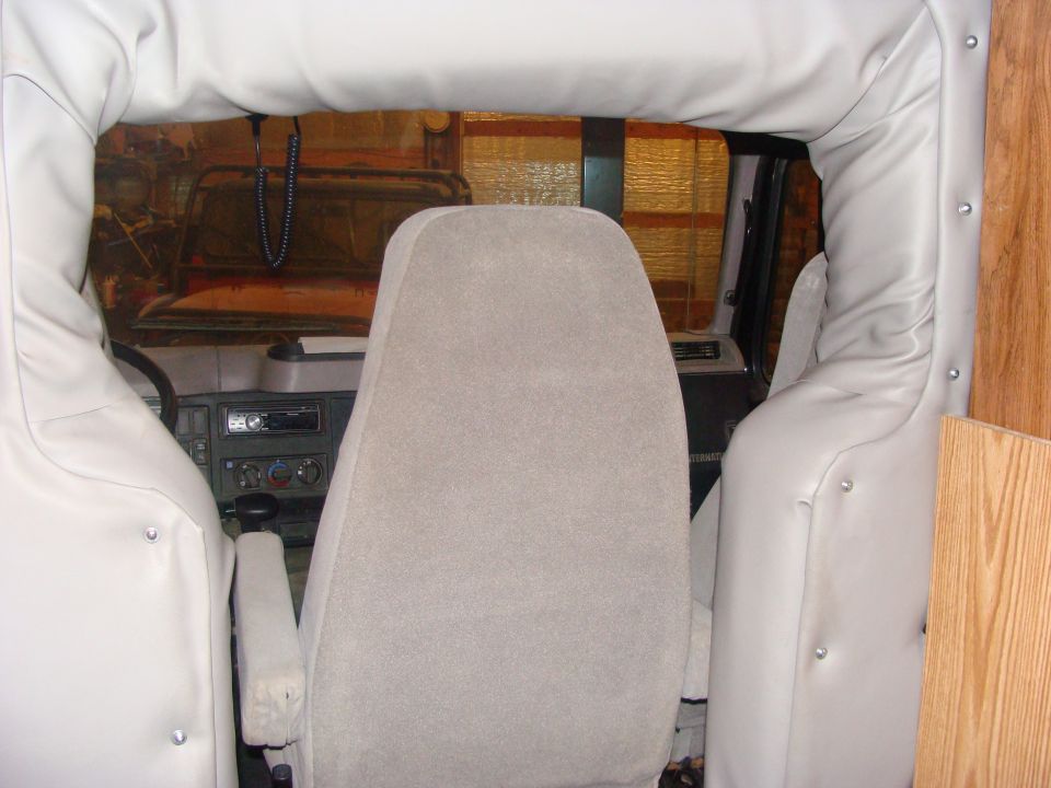 Interior view showing dashboard, steering wheel, and seats. A beaded string hangs from the rearview mirror