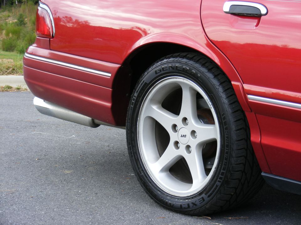 Rear wheel of red sedan with silver 5-spoke SVT alloy and General tire