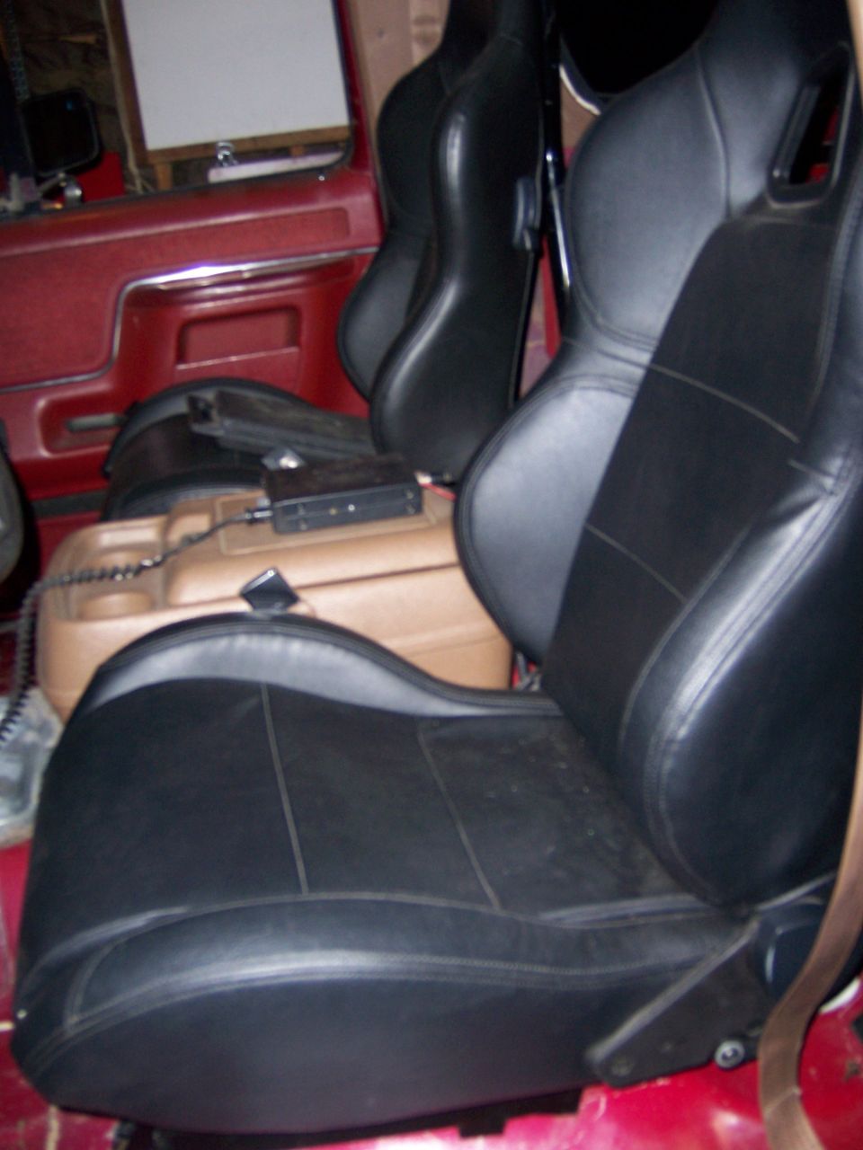 aftermarket bucket seats in vehicle interior, with center console and equipment