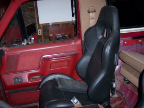 1991 Ford Bronco - Vehicle interior with racing seats and red door panels visible.