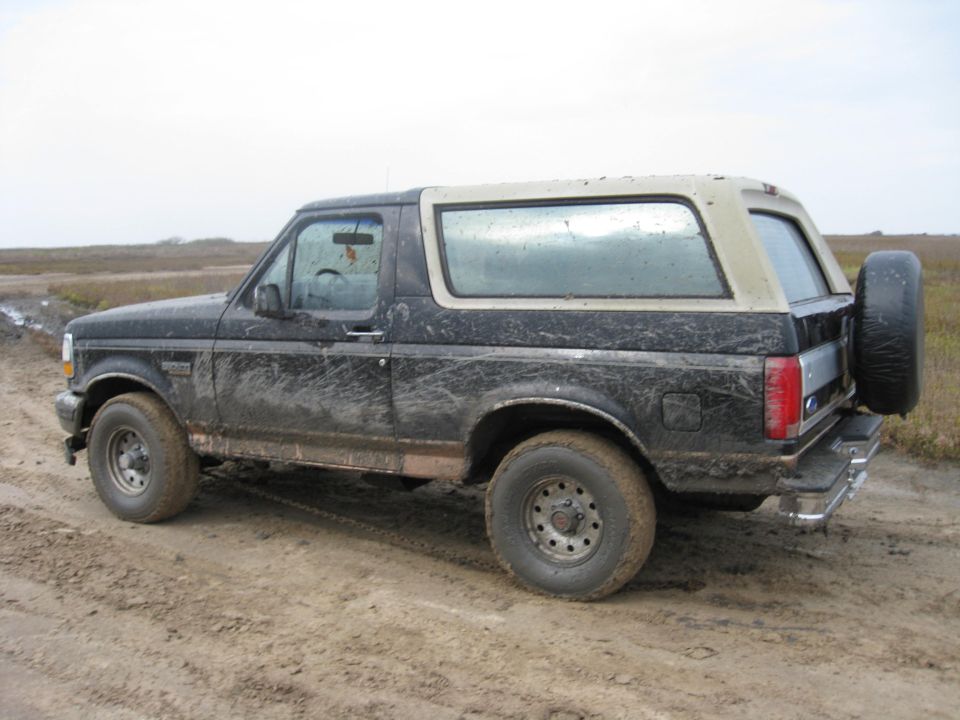 Mud-covered 1994 Ford Bronco parked on a dirt road