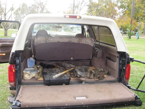 1994 Ford Bronco - The cargo area of a 1994 Ford Bronco contains various items, including a toolbox and what appears to be hunting gear.