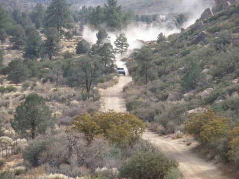 2008 Ford Bronco - An SUV navigates a dusty trail in a , natural landscape.