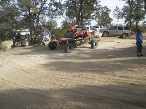 2008 Ford Bronco - A custom off-road buggy with Monster Energy branding is parked in a dusty area, with several people and other vehicles nearby.