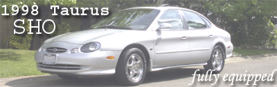 1998 Ford Taurus - This 1998 Ford Taurus SHO is shown parked on the side of the road with trees in the background.