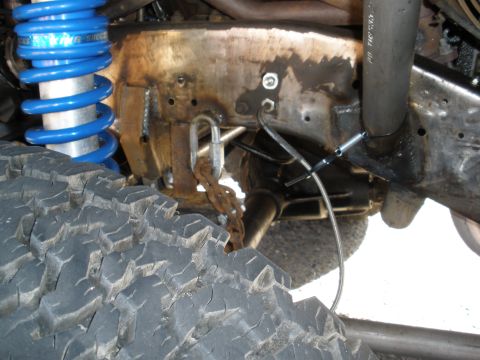 2008 Ford Bronco - Close-up of off-road suspension components, including a tire and shock absorber, on a modified vehicle.
