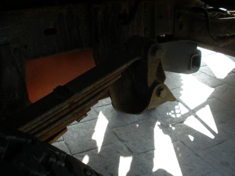 2008 Ford Bronco - Close-up of a vehicle's leaf spring suspension system, showing rust and wear.