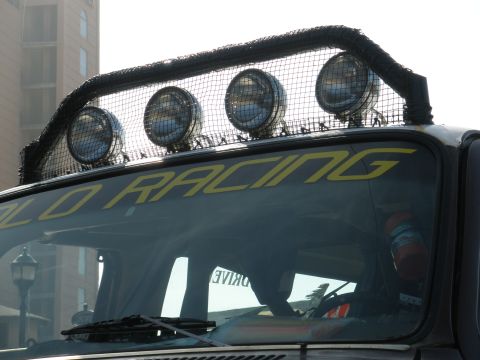 2008 Ford Bronco - A close-up view of an off-road vehicle's roof, a light bar and yellow "RACING" decals on the windshield.
