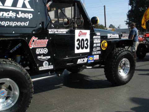 2008 Ford Bronco - This modified Jeep is covered in sponsor decals and racing numbers, suggesting it's prepared for competition.