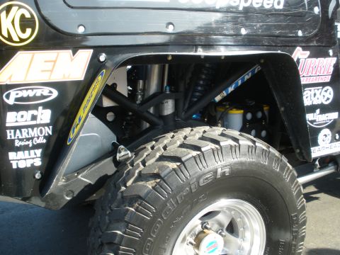 2008 Ford Bronco - Close-up view of the modified suspension and tire of a custom off-road vehicle.