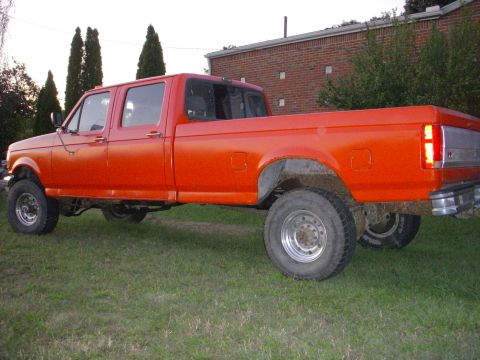 1992 Ford F-350 - This orange 1992 Ford F-350 crew cab pickup truck is parked on grass.