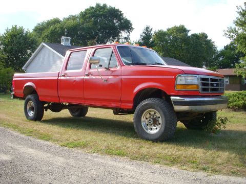 1992 Ford F-350 - This red 1992 Ford F-350 crew cab pickup truck is shown from a 3/4 front angle.