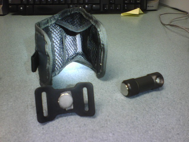 Black flashlight and holster with magnetic clip