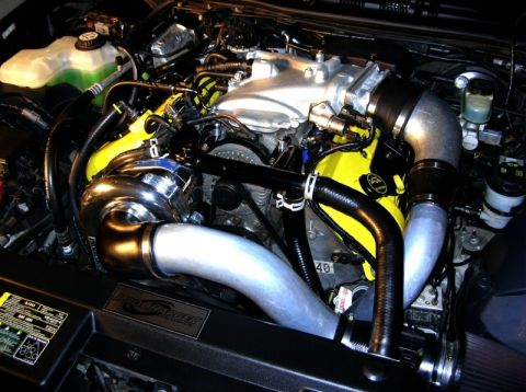 2003 Mercury Marauder - Customized engine bay a turbocharger and bright yellow components, with a Supermotors.net watermark.