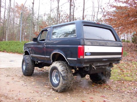 1992 Ford Bronco - Modified 1992 Ford Bronco with lifted suspension and oversized tires parked outdoors.