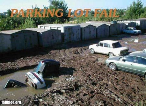 2000 Mercury Grand Marquis - Multiple vehicles are stuck in a muddy area, with garages visible behind them.