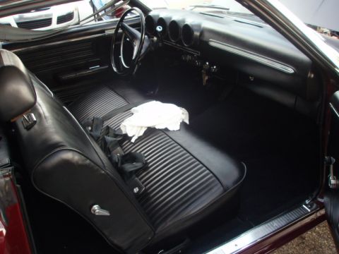 1969 Ford Torino - The interior of a classic car features black vinyl seats and a dashboard with three prominent gauges.