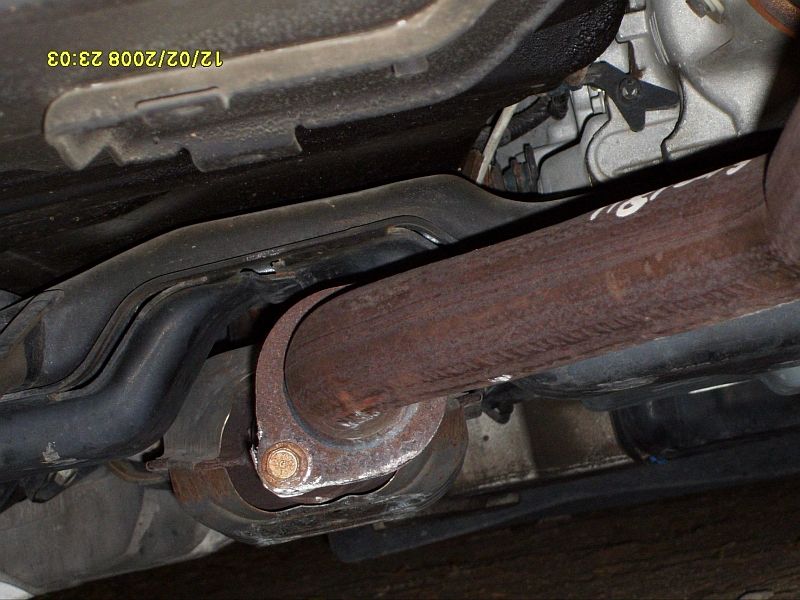 Undercarriage view of rusty exhaust pipe and suspension components