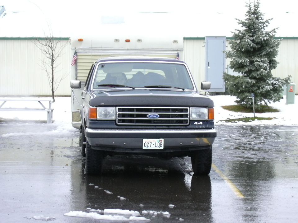Front of dark Ford F-150 4x4 pickup in a snowy lot with Colorado plate 0Z7-LQB