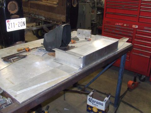 1967 Ford Bronco - Metal fabrication in progress on a workbench, with tools and a Corona beer box nearby.