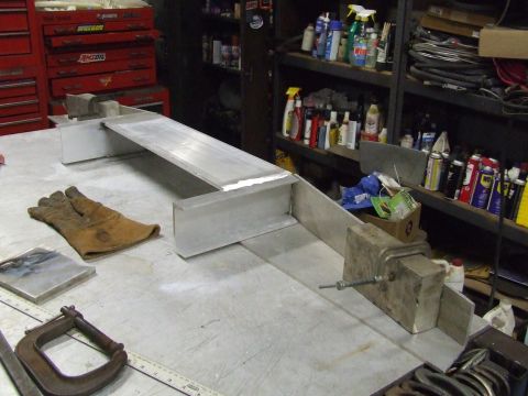 1967 Ford Bronco - A metal fabrication project is underway on a workbench, with tools and supplies in the background.