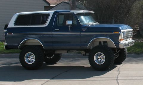 1978 Ford Bronco - This lifted 1978 Ford Bronco features a two-tone blue and white paint scheme and prominent chrome wheels.