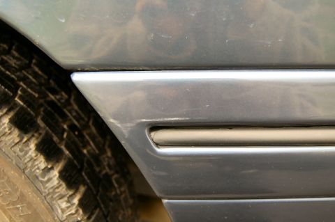 1985 Mercury Grand Marquis - A close-up shows the side trim and a portion of the tire on a vehicle.