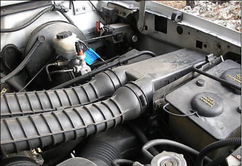 1995 Ford Bronco - Close-up view of engine bay components including air intake hoses and brake fluid reservoir.
