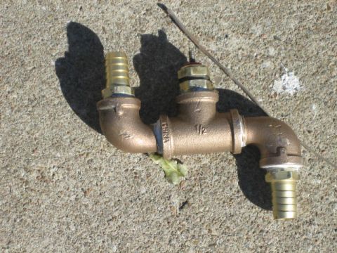 1996 Ford Thunderbird - A brass plumbing T-fitting with two hose barbs and a valve is shown on a concrete surface.