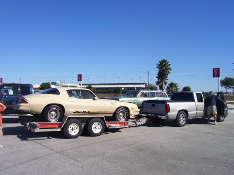 1979 Chevrolet Camaro - A tan 1979 Chevrolet Camaro Z28 is transported on a trailer, alongside other vehicles.