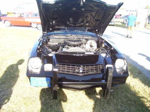 1979 Chevrolet Camaro - A black Chevrolet Camaro from the late 1970s is displayed with its hood open, revealing the engine compartment.
