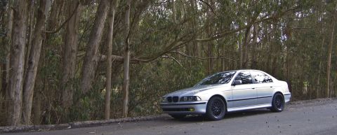 1996 Ford Probe - A silver sedan is parked on the side of a road surrounded by trees. The vehicle appears to be a BMW.