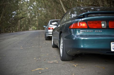 1996 Ford Probe - Rear view of a 1996 Ford Probe parked on a road with another vehicle behind it.