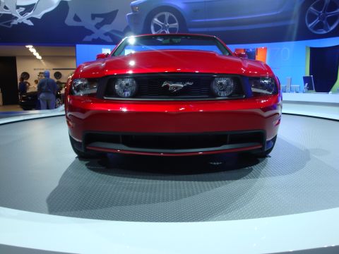 1993 Ford Taurus - This red Ford Mustang is displayed on a rotating platform at an auto show.