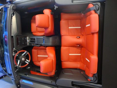 1993 Ford Taurus - The interior of a vehicle is shown, bright orange leather seats and a black dashboard with a multi-function steering wheel.