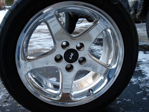 1998 Ford Taurus - A close-up of a chrome SVT wheel, with another vehicle's wheel visible in the background.
