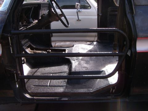 1978 Ford Bronco - Interior view of a black truck with custom tube doors, revealing the floor and dashboard area.