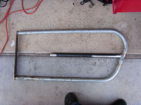 1978 Ford Bronco - A homemade tube door frame lying on a concrete garage floor, bent from galvanized pipe with rounded corners and a straight middle brace wel…