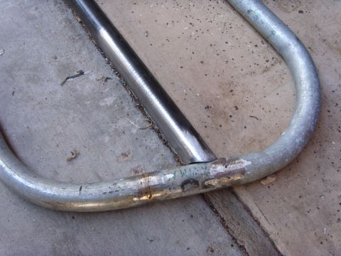1978 Ford Bronco - Close-up of a fabricated tube frame on concrete, showing a fish-mouthed crossbar welded into the bent galvanized outer tube with a clean st…