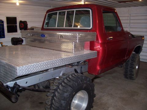 1978 Ford F-150 - This red 1978 Ford F-150 pickup features a custom flatbed and a diamond plate toolbox mounted behind the cab.