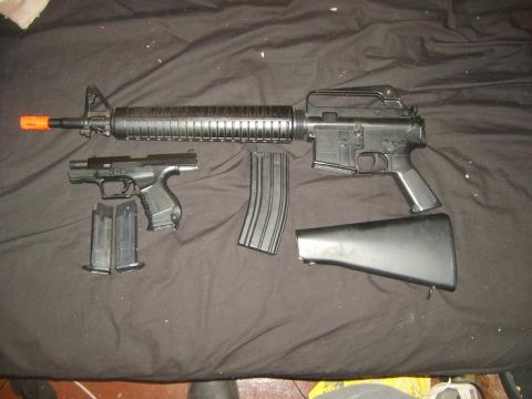 2000 Mercury Grand Marquis - A disassembled assault rifle and pistol with magazines are displayed on a dark fabric surface.