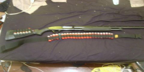 2000 Mercury Grand Marquis - A shotgun and ammunition belt are laid out on a dark surface.