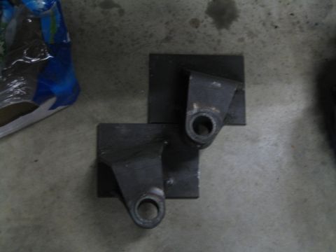 1996 Ford Bronco - Two metal brackets are shown on a concrete surface, possibly for automotive use.