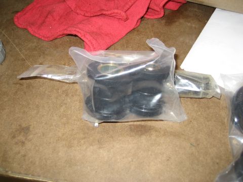 1996 Ford Bronco - New suspension bushings are shown in plastic packaging on a workbench.