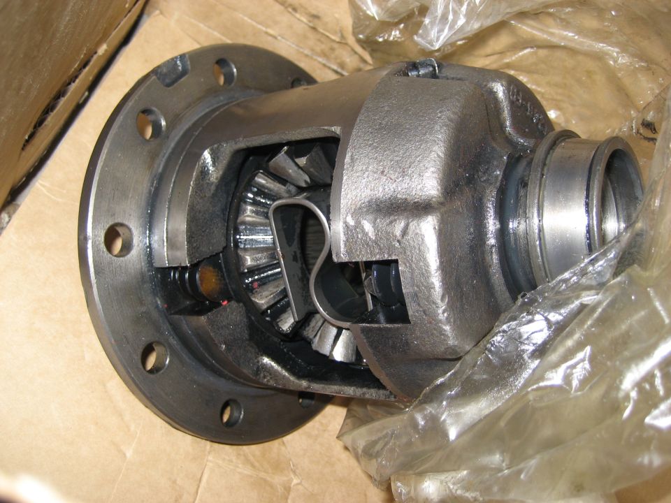 Close-up of a differential with gears visible inside. It's partially wrapped in plastic