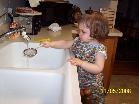 2000 Ford Crown Victoria - A young child curiously interacts with a kitchen sink and strainer, with a date stamp of 11/05/2008 visible.