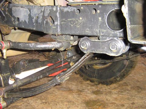 1990 Ford Bronco - Close-up of the undercarriage, showing the suspension and frame structure of a vehicle.