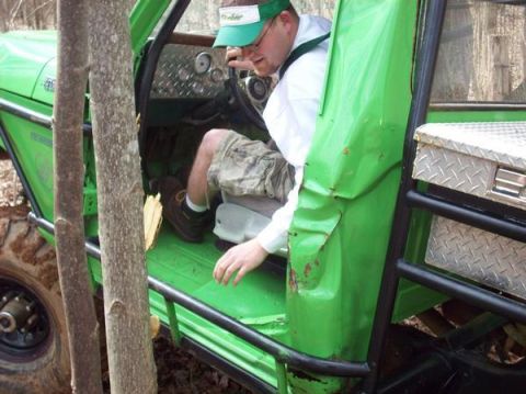 1978 Ford Bronco - A person enters a modified off-road vehicle, which appears to be in a wooded area.
