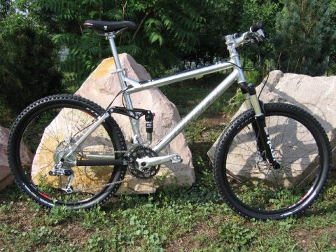 1972 Ford Ranchero - A silver full-suspension mountain bike is shown outdoors, leaning against rocks.