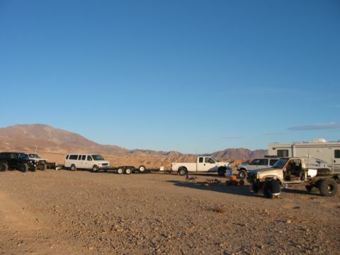 1997 Ford Ranger - A collection of vehicles, including trucks and a van, are gathered in a desert environment under a clear blue sky.
